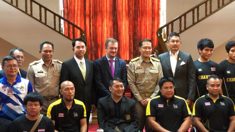 a group of officials and wheelchair athletes standing together