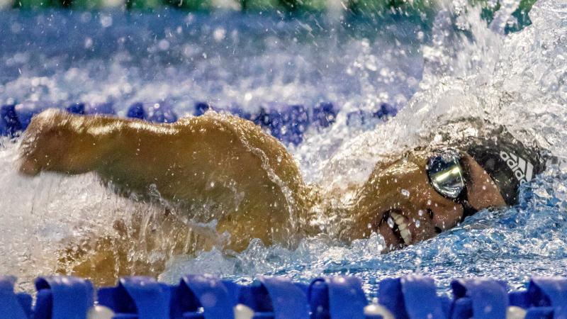 a male Para swimmer mid-freestyle stroke