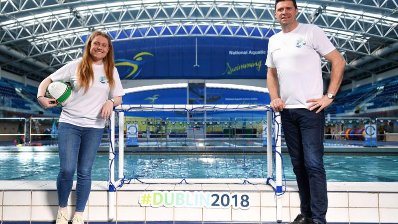 A woman and a man standing in front of a swimming pool