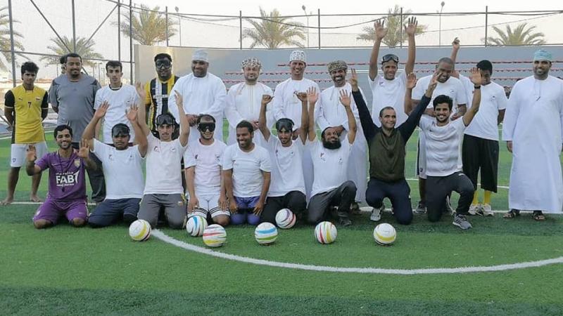 a group of blind footballers line up on a pitch