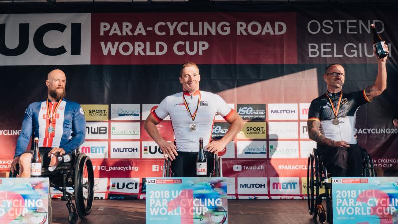 three male Para cyclists on the podium