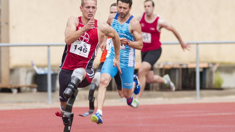 a group of male double amputee runners come round the bend