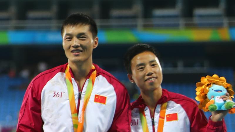 a female vision impaired athlete and her male guide on the podium