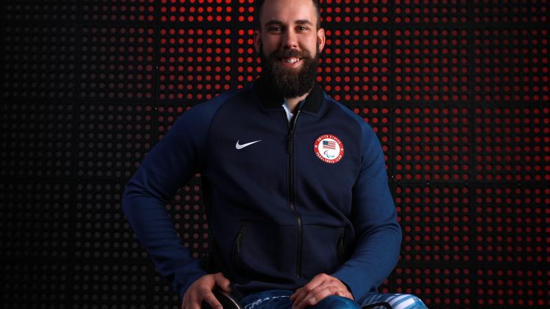 a male wheelchair athlete smiles at the camera