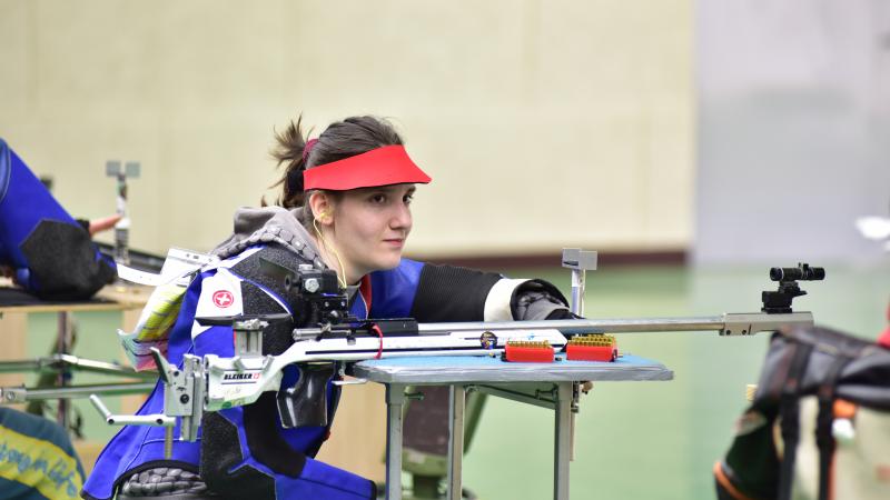 Female shooter holds rifle in prone position