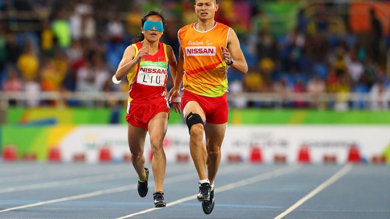 Two runners sprint towards the finish line. 