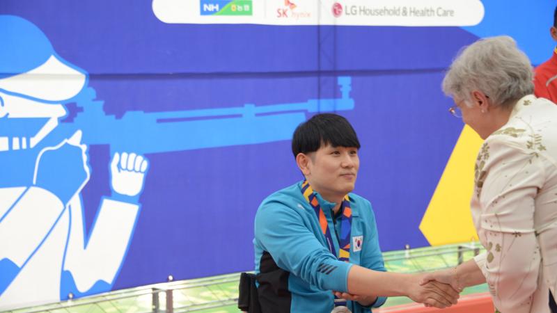 a male Para shooter receives his medal