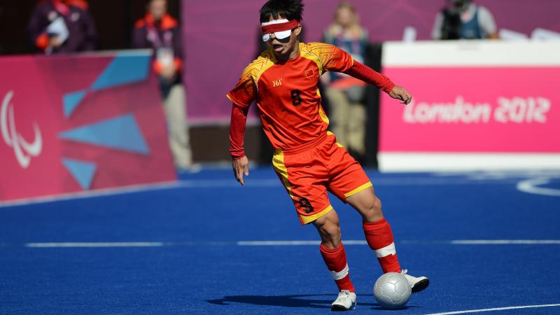 a blind football player dribbling with the ball
