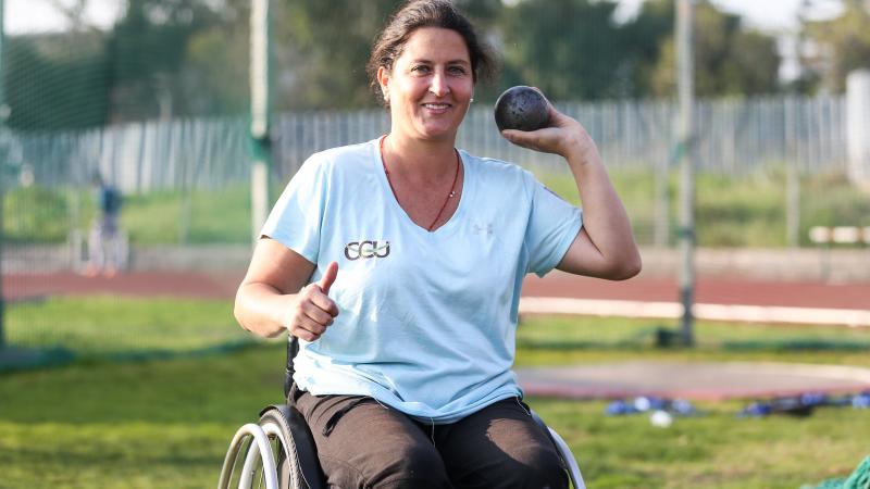 a female Para athlete prepares to throw a shot put