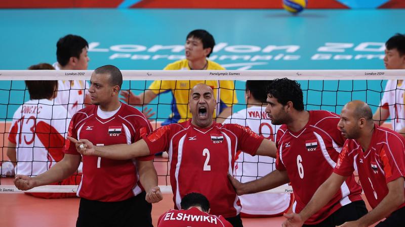 a men's sitting volleyball celebrate and shout on the court