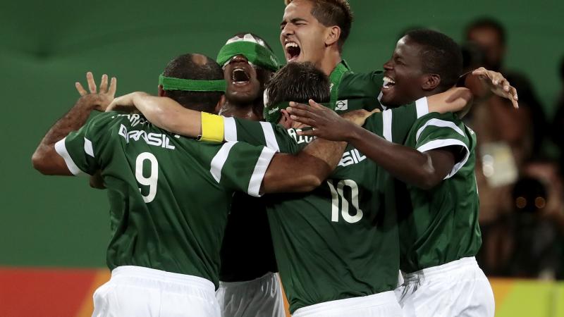 Five Brazilian blind football players celebrating