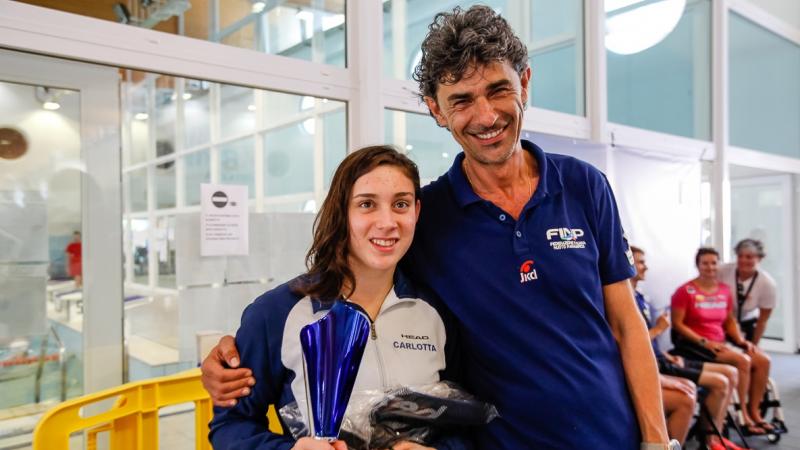 a female Para swimmer is hugged by her coach