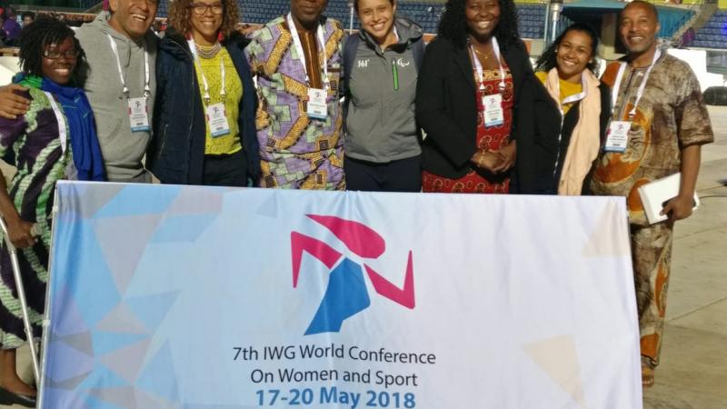 a group of women standing behind a flag