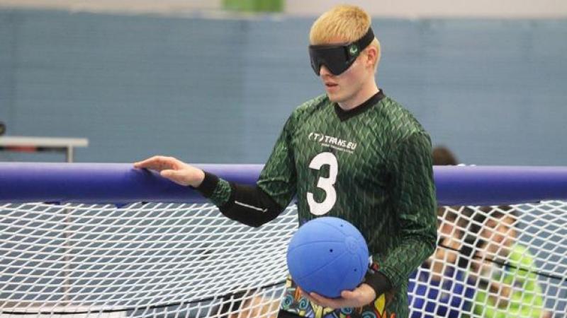 a male goalball player stands at the net