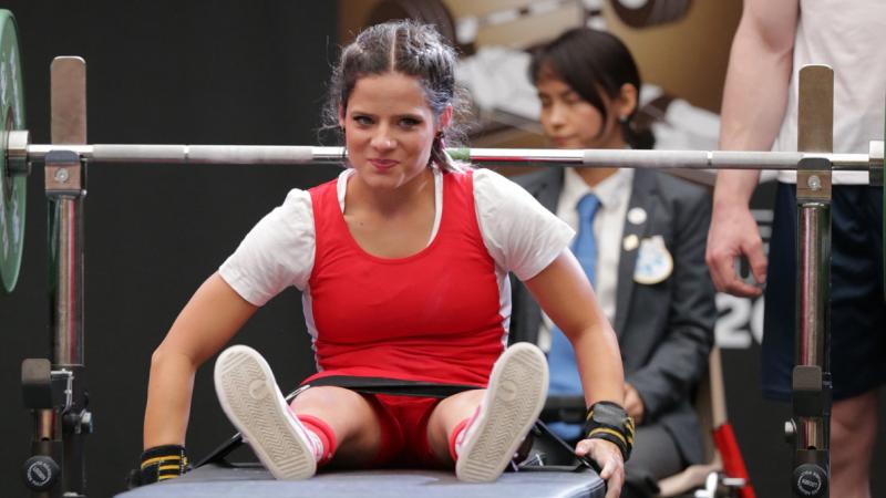 a female powerlifter smiling on the bench