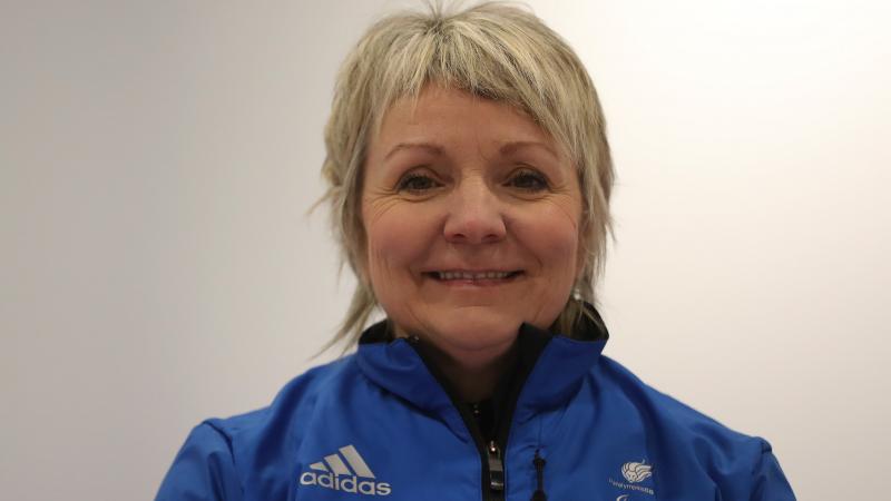 a female wheelchair curler smiles for the camera