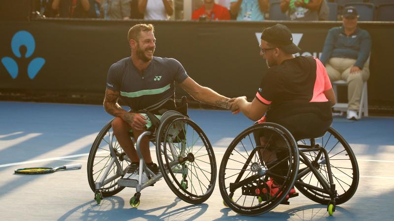 Two men in wheelchairs shake hands