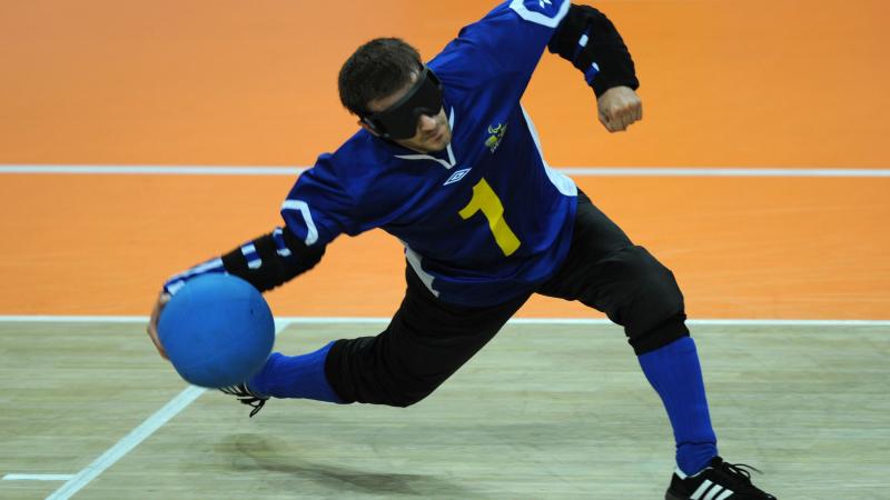 a male goalball player prepares to throw the ball