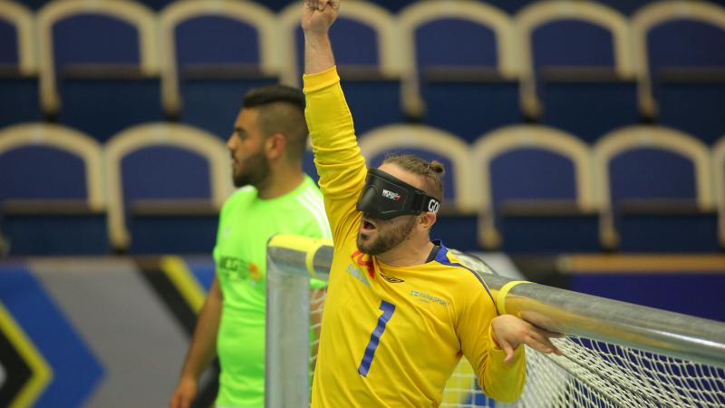 a male goalball player punches the air in celebration