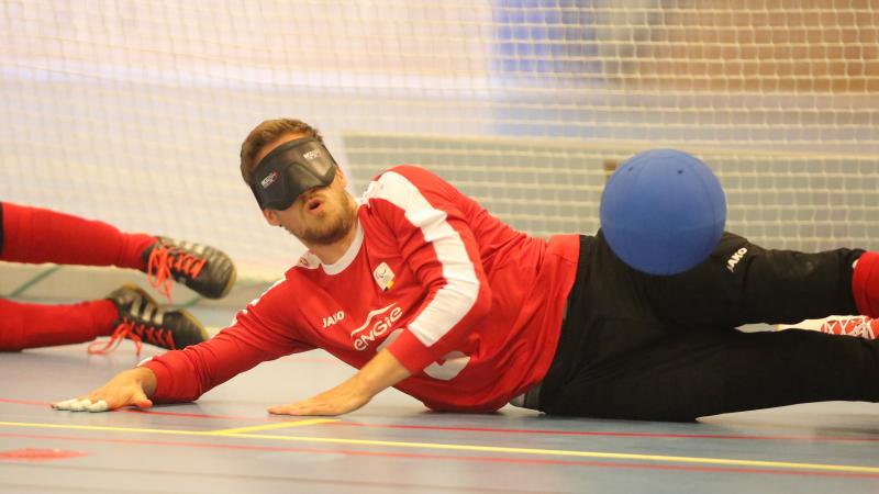 a male goalball player saves a shot