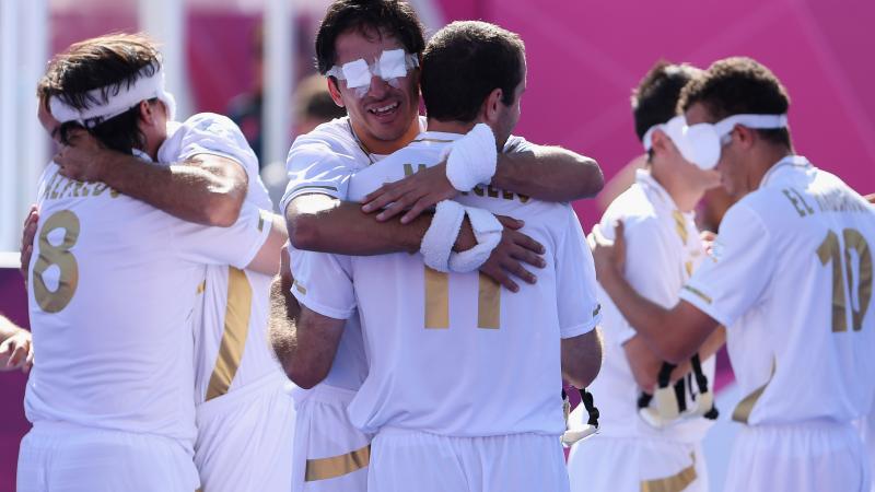 a group of blind footballers hugging eachother