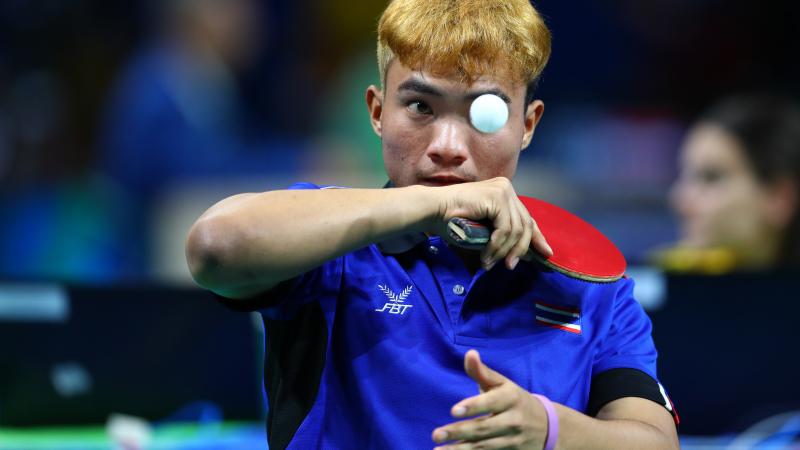 Man trying to hit a table tennis ball