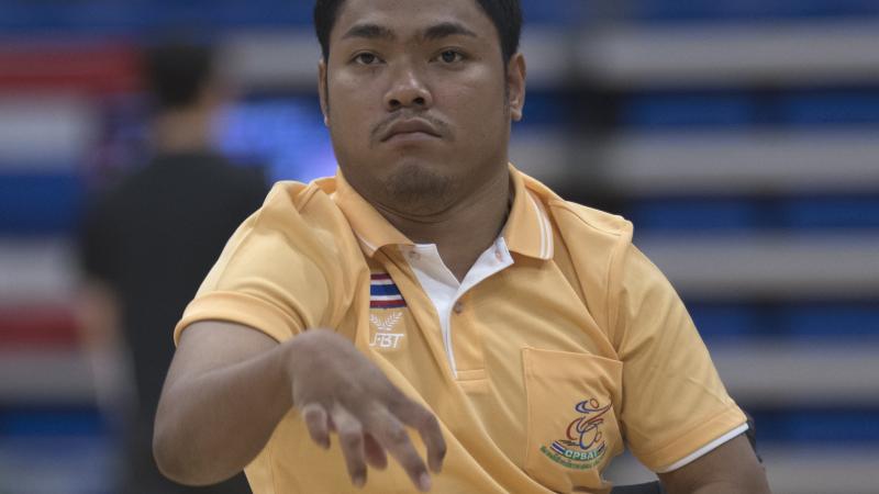 a male boccia player throws a ball