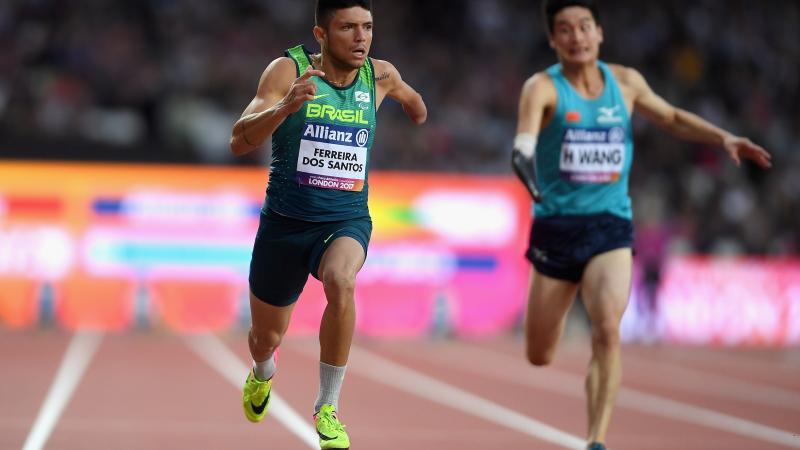 a male Para sprinter crosses the finish line