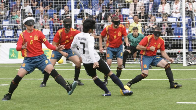 a group of blind footballers in action on the pitch