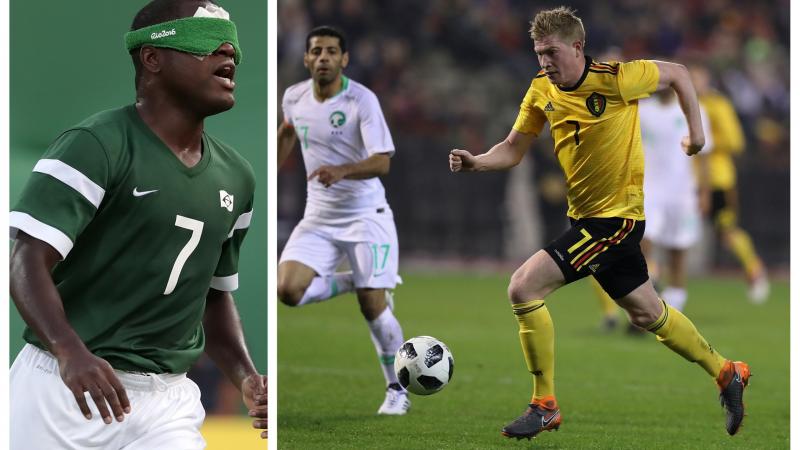 a male blind football player and a male able-bodied footballer dribbling with the ball