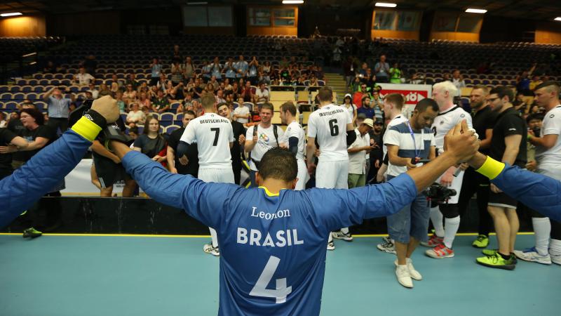 Brazilian goalball player raises arms after winning 