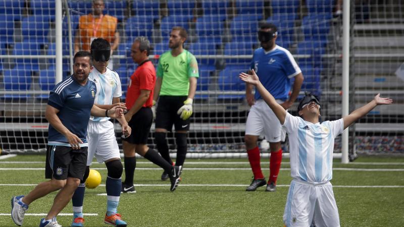 a male blind footballer celebrates on his knees after scoring a goal