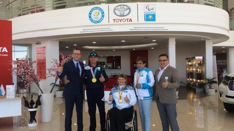 a group of people standing in front of a Toyota sign