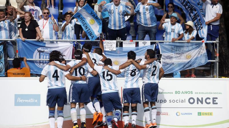 a group of blind footballers celebrating with the crowd