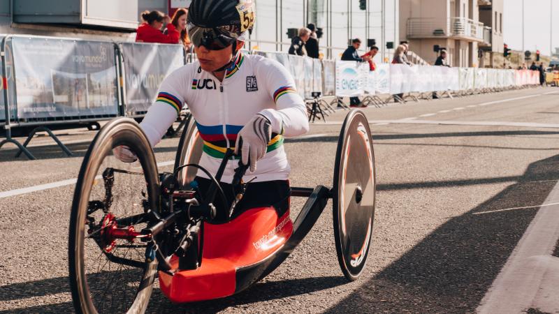 a female hand-cyclist begins a road race