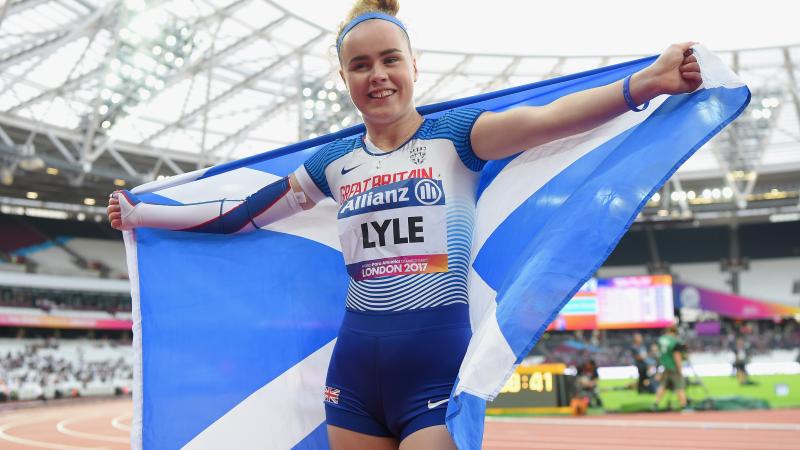 A female Para sprinter holding up a Scotland flag