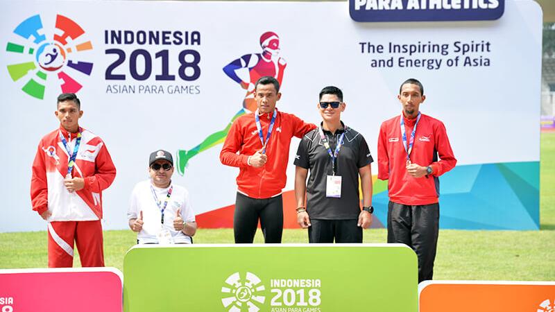 Athletes and their guides pose on the podium