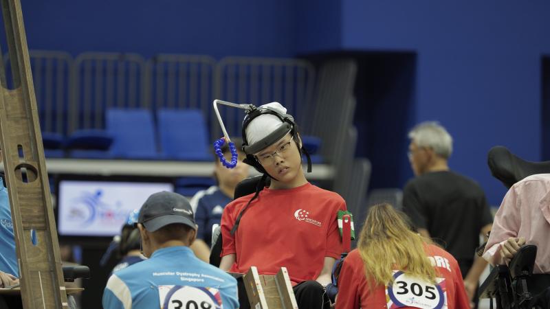 Boccia athlete Toh Sze Ning and her assistant get ready to roll ball down ramp