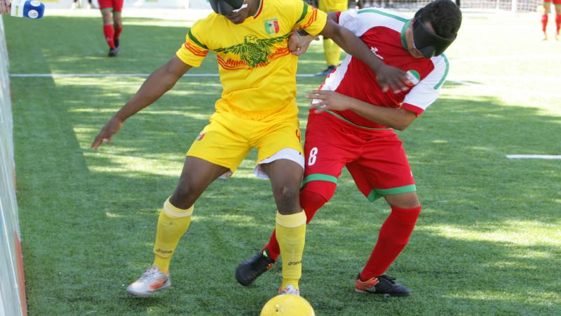 Two blind football players battle for the ball