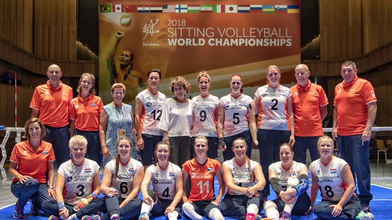 Princess Margriet and a group of female sitting volleyball players grouped together on a court