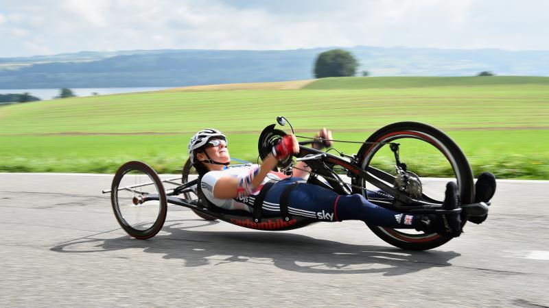 female British Para cyclist Karen Darke racing with a hand-bike on a road