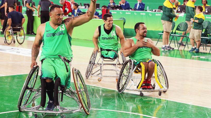 Three Brazilian men wheelchair basketball players wave at home crowd