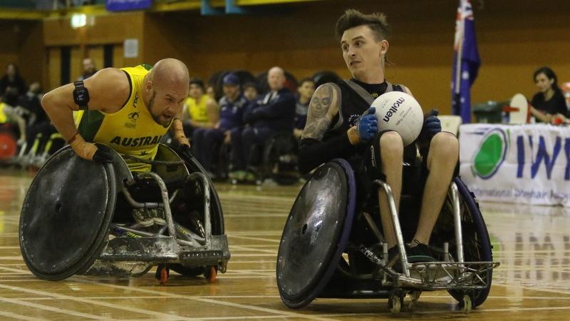 male wheelchair rugby player Cody Everson takes the ball away from another player