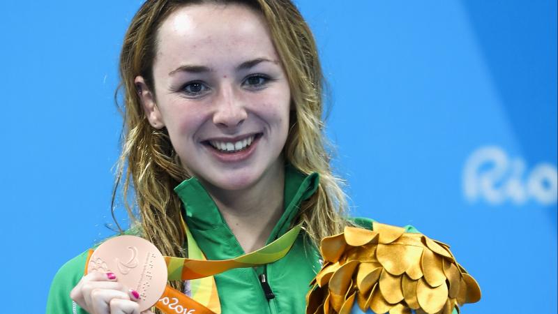 Young woman smiling showing a bronze medal