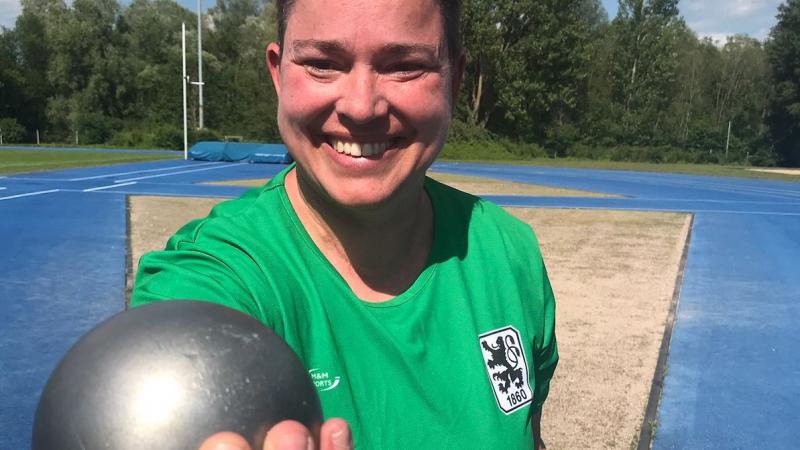 female Para athlete Birgit Kober smiling and holding a shot put
