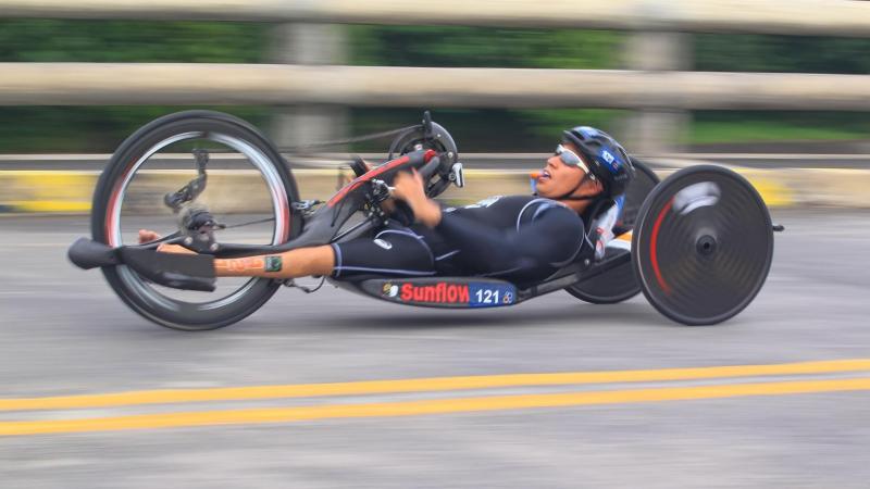 male Para triathlete Jumpei Kimura competing on a hand bike