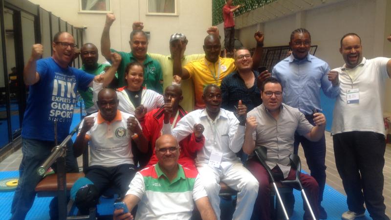 a group of African powerlifting officials smile for the camera