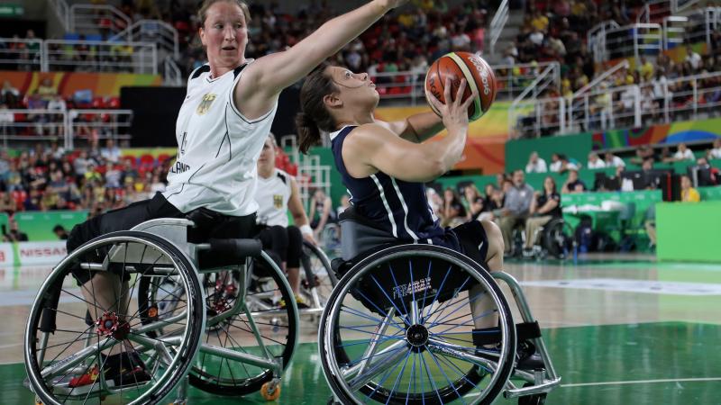 female wheelchair basketballer Marina Mohnen reaches over another player to block the ball