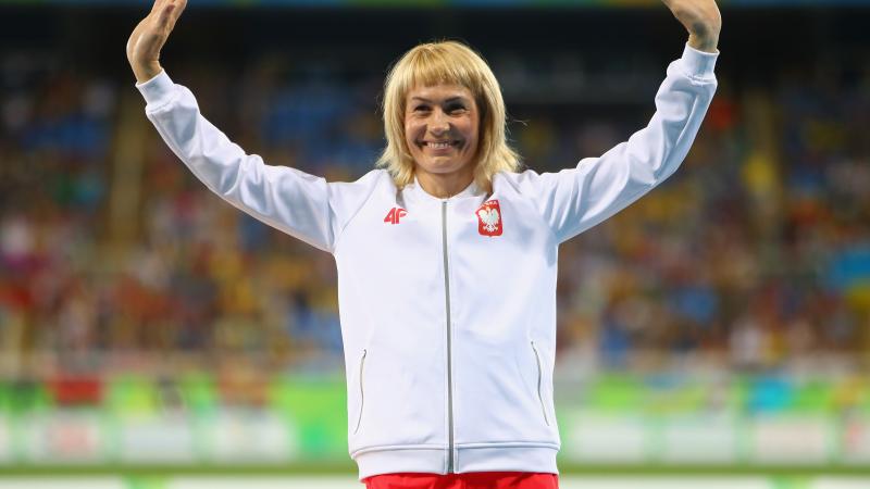 female Para sprinter Barbara Niewiedzial raises her arms on the podium