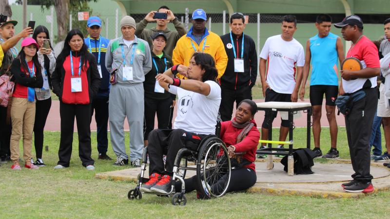 a male wheelchair athlete prepares to throw a shot put